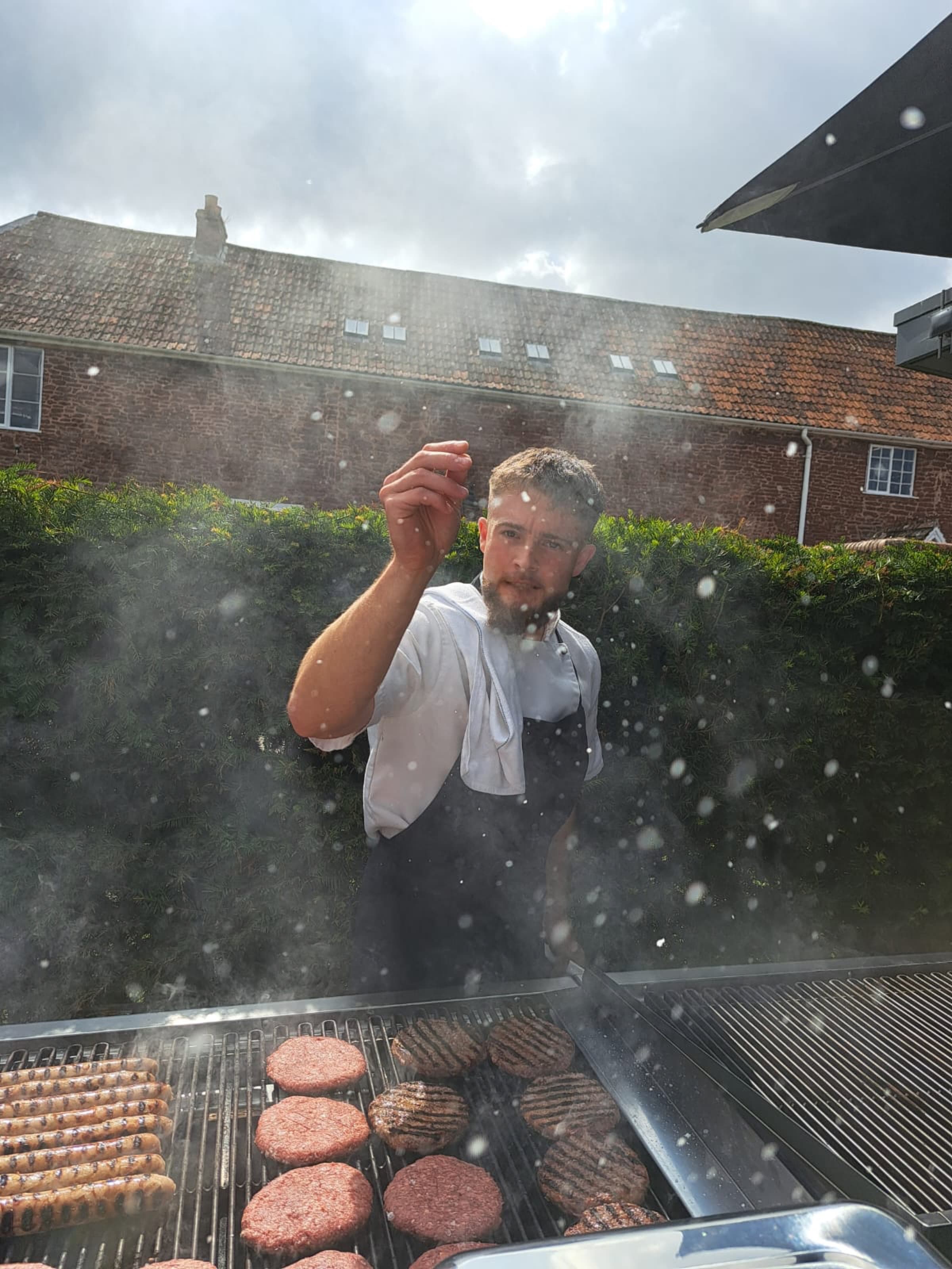 Samuel seasoning the grill through smoke