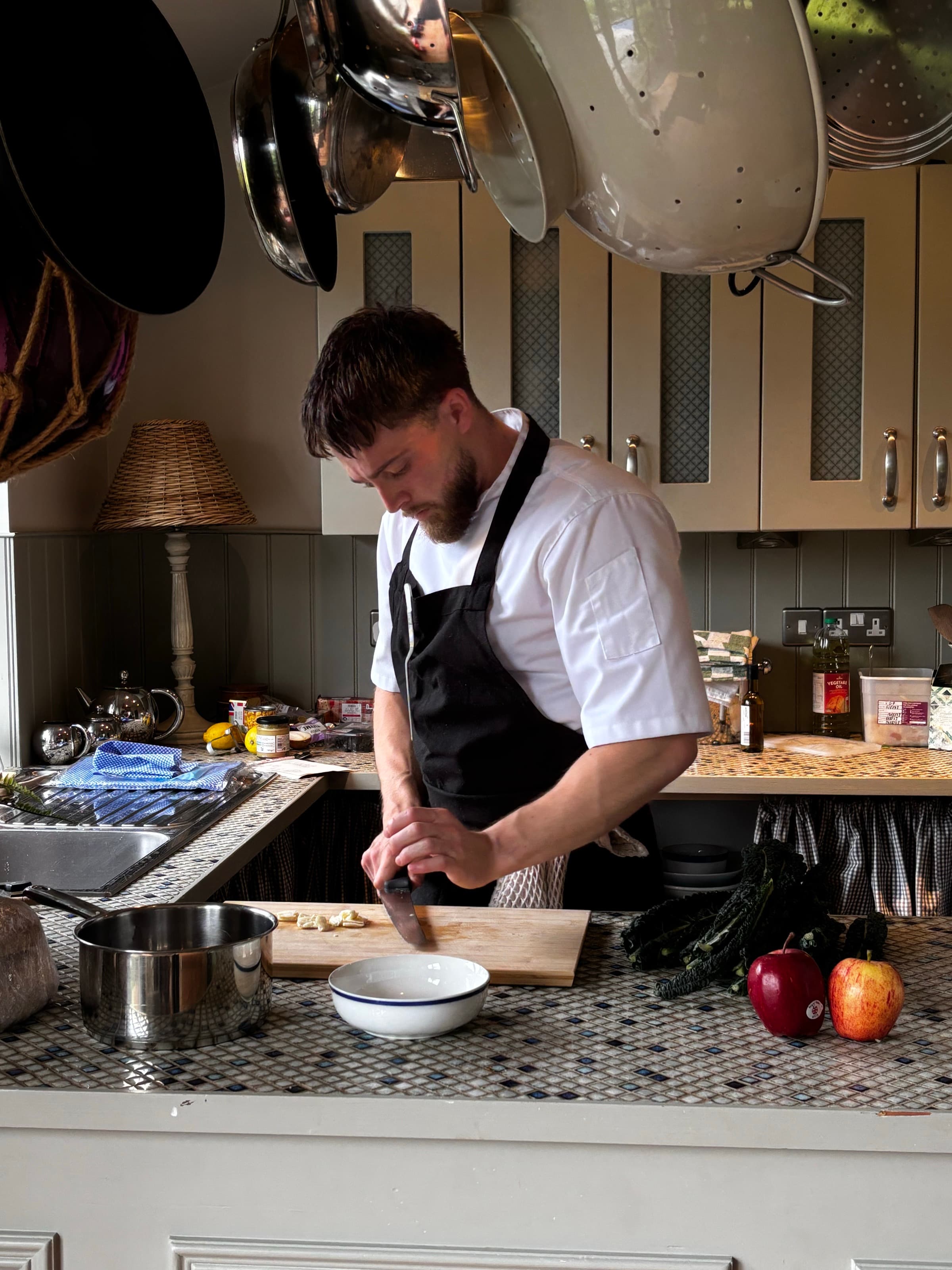 Samuel at the board in a lamplit cottage kitchen