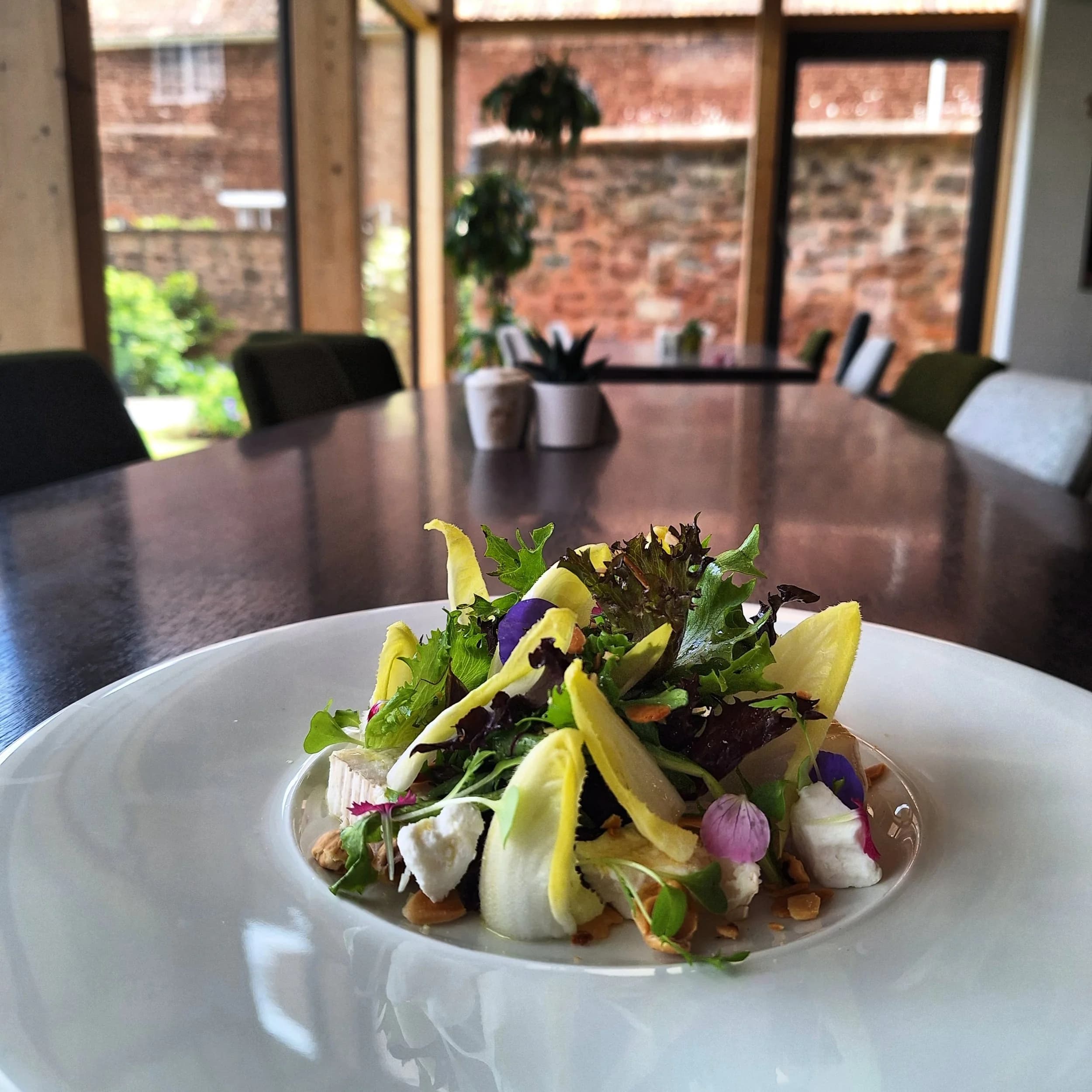 A composed salad scattered with edible flowers